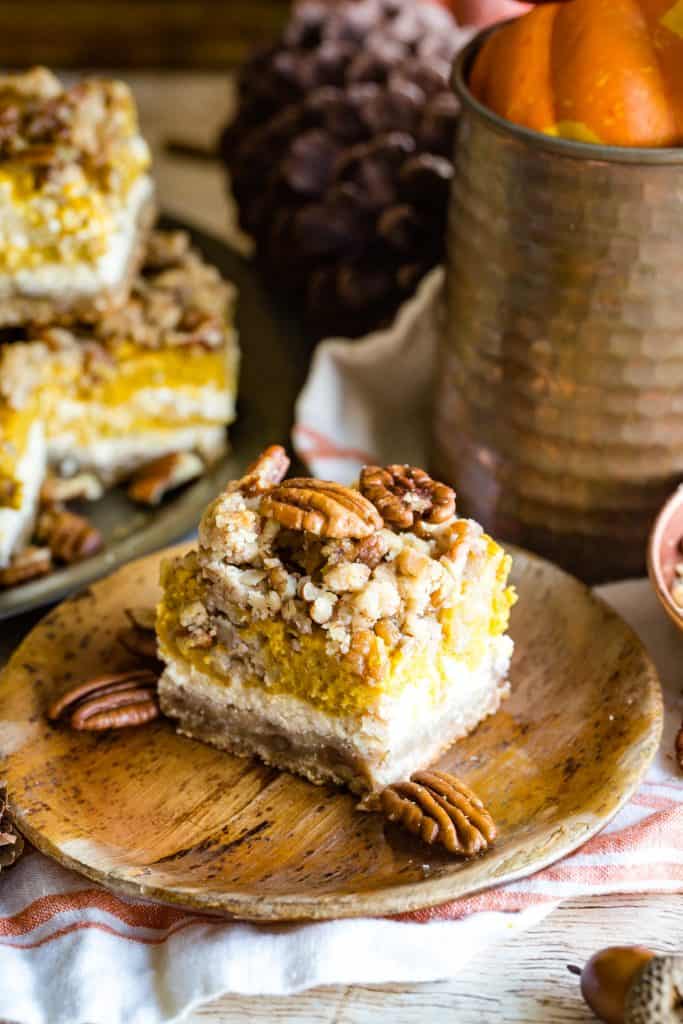 wood plate with pumpkin cream cheese bar and pecans