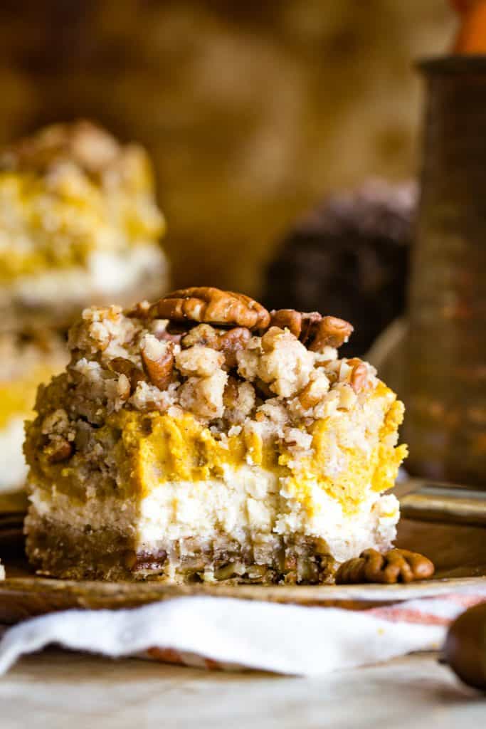 wooden plate of pumpkin cream cheese bar with bite taken out