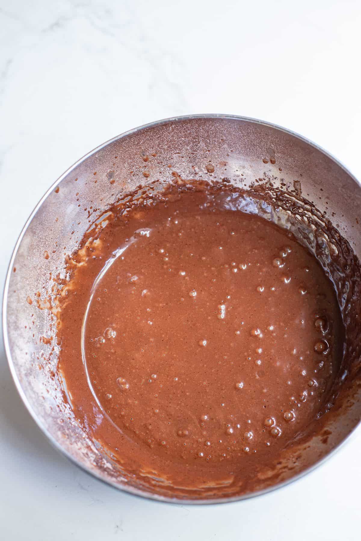 chocolate cake batter in metal bowl on white background