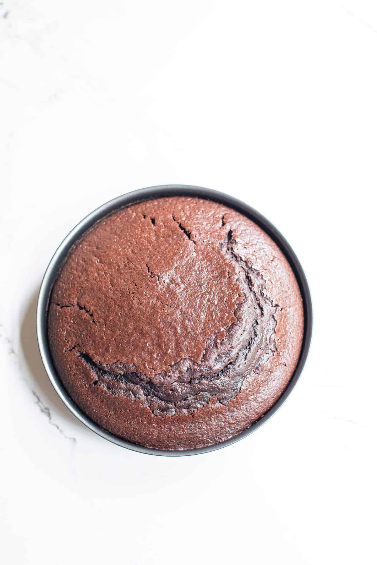 baked chocolate cake in metal tin on white background