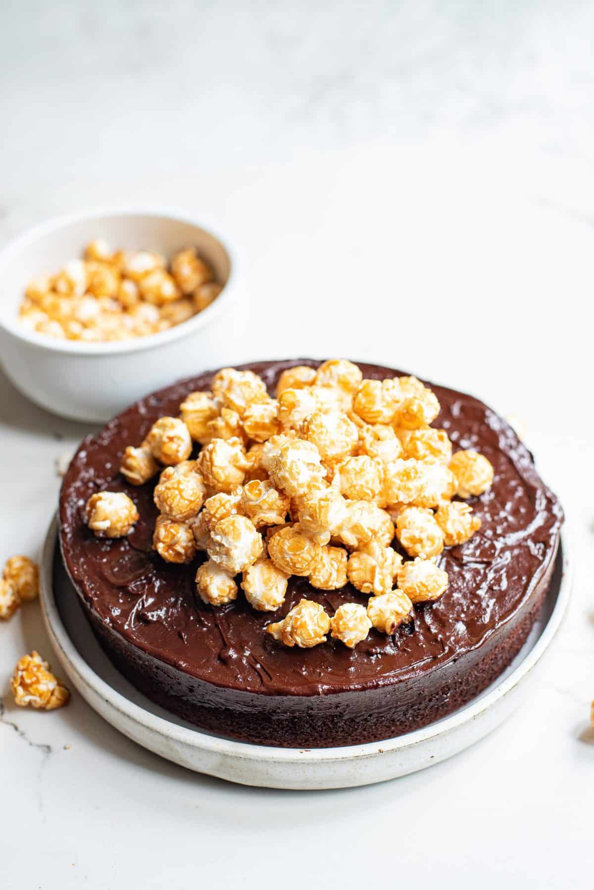 placing the caramel corn on frosted chocolate cake