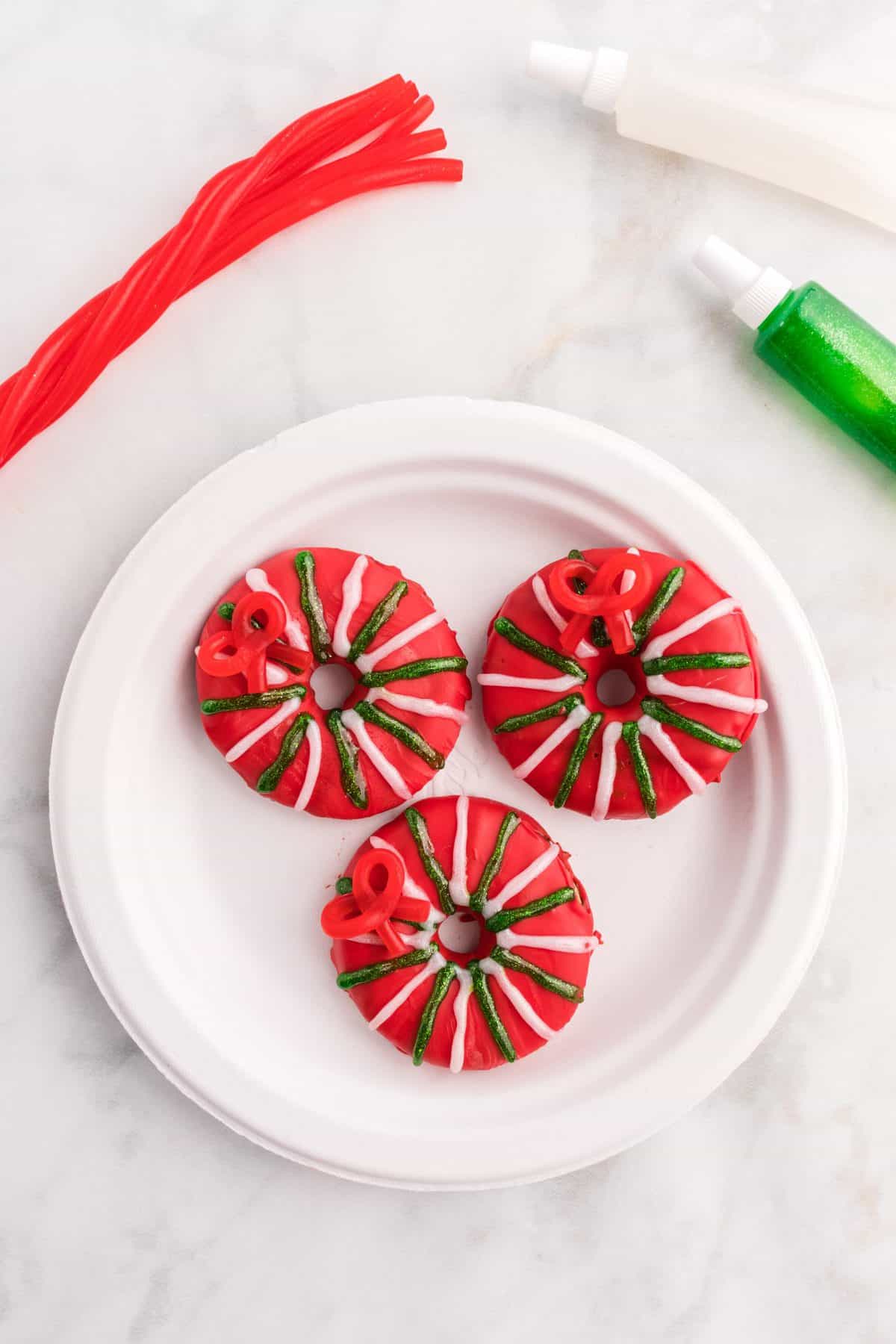 red Christmas wreath cookies on white plate