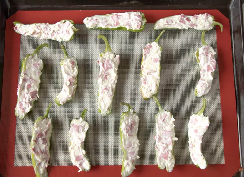 slices jalapenos stuffed with cream cheese on a tray