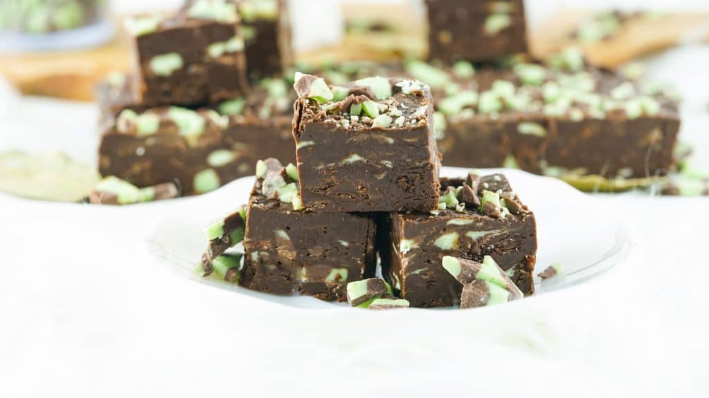 mint chocolate fudge squares stacked on white plate