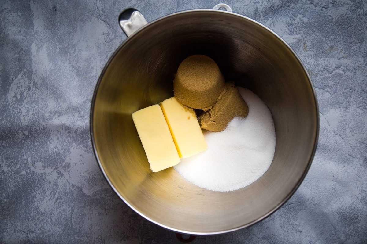 adding the butter, sugar, and brown sugar to a metal bowl for creaming