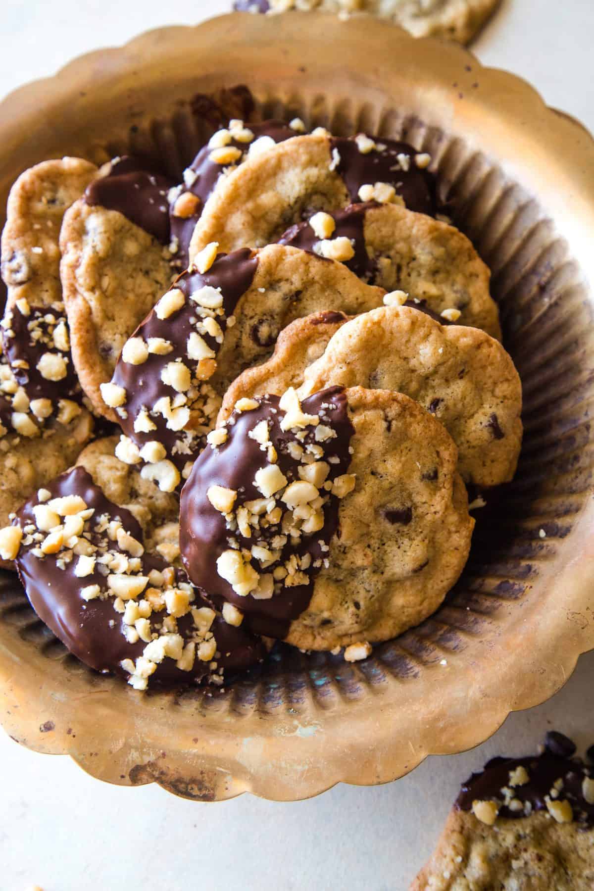 large gold bowl of chocolate dipped macadamia nut cookies 