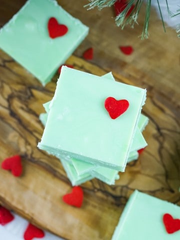 grinch fudge green squares stacked on a wood board