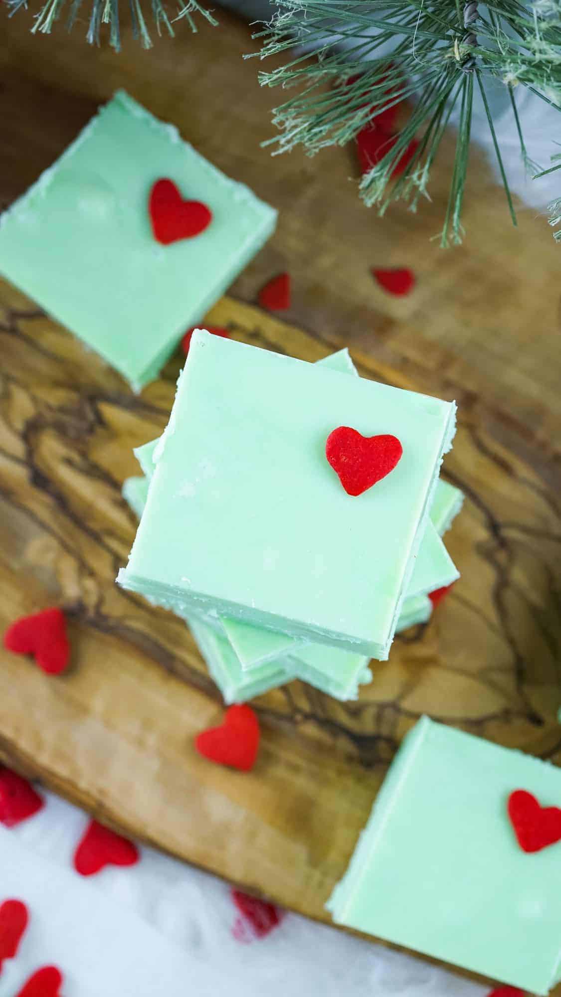 grinch fudge green squares stacked on a wood board