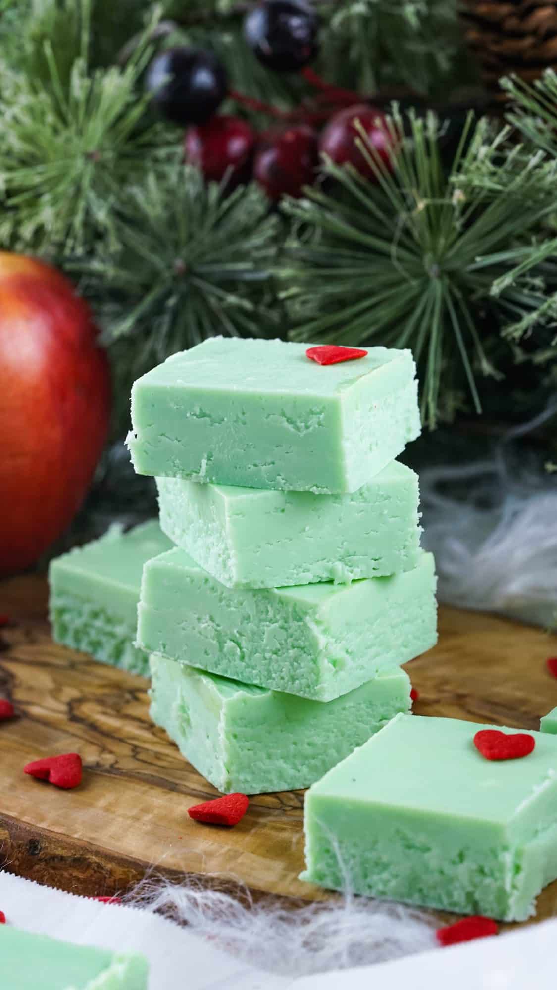 green grinch fudge 4 stacked squares on a wood cutting board