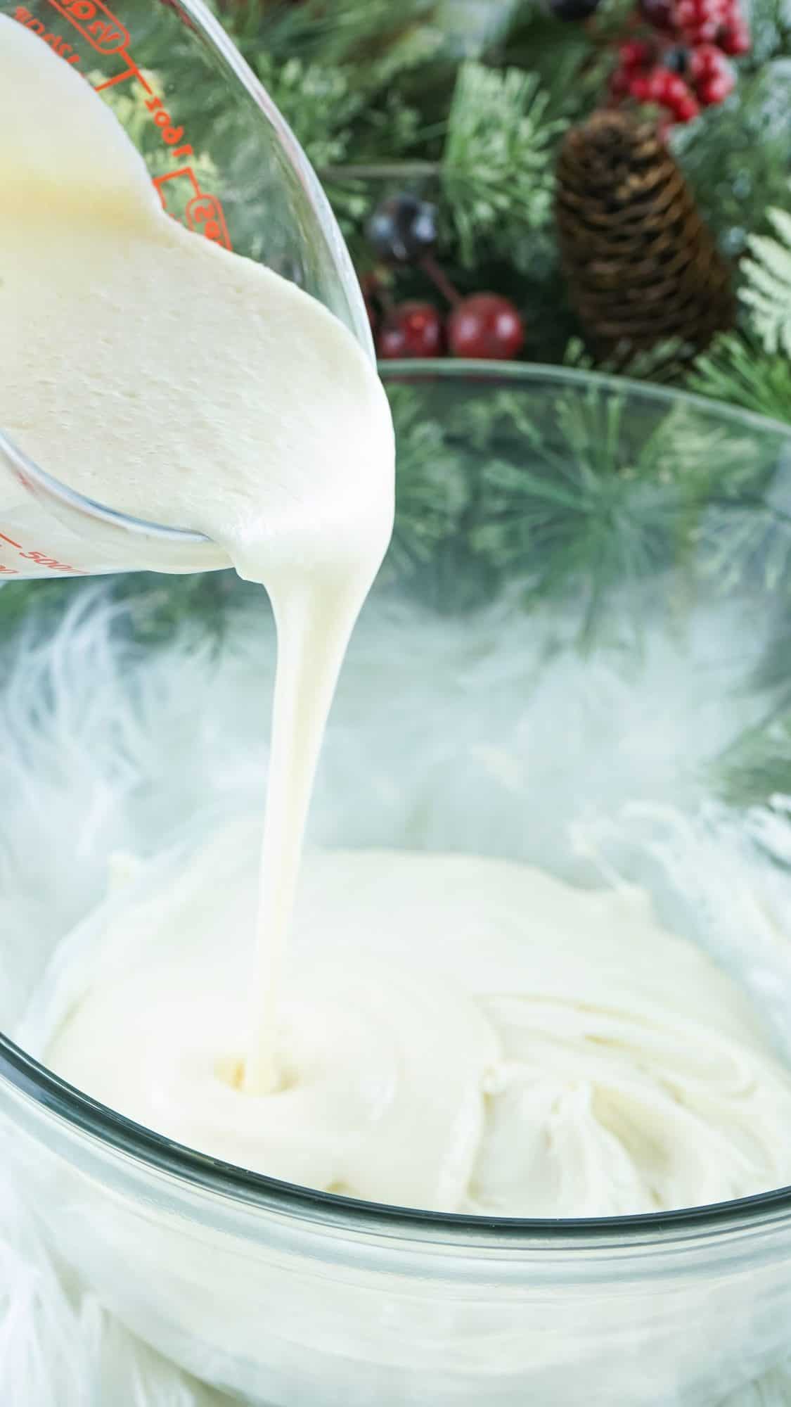 pouring the melted frosting into glass bowl with white chocolate 