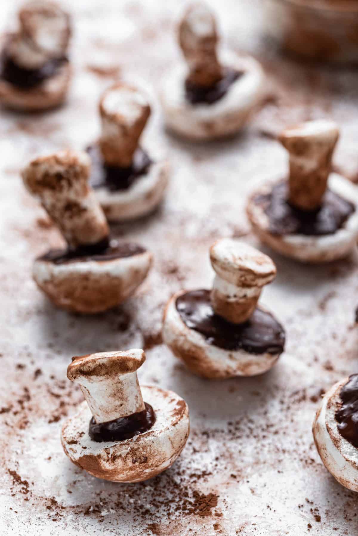 assembling the meringue mushrooms on cookie sheet