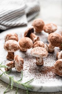 plate of meringue mushrooms on white background
