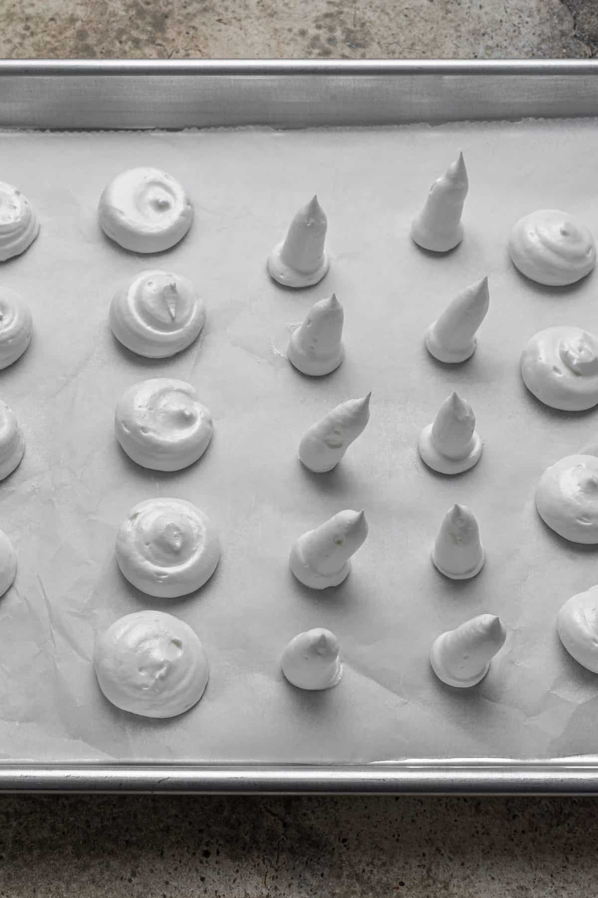 piping the mushroom stems and caps on parchment paper