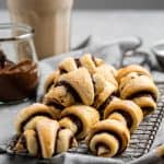 a plate of the best rugelach cookies with strawberry jam and a latte in background