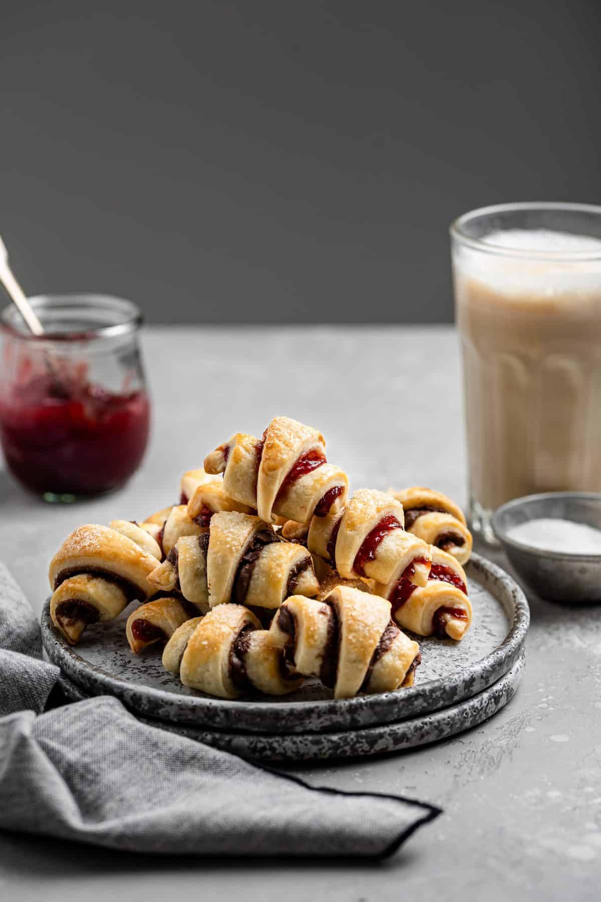 a plate with rig leach cookies with a jar of jam and cup of coffee in the background