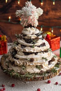 stacked pavlova and cherry filling to look like a tree on wood cake plate