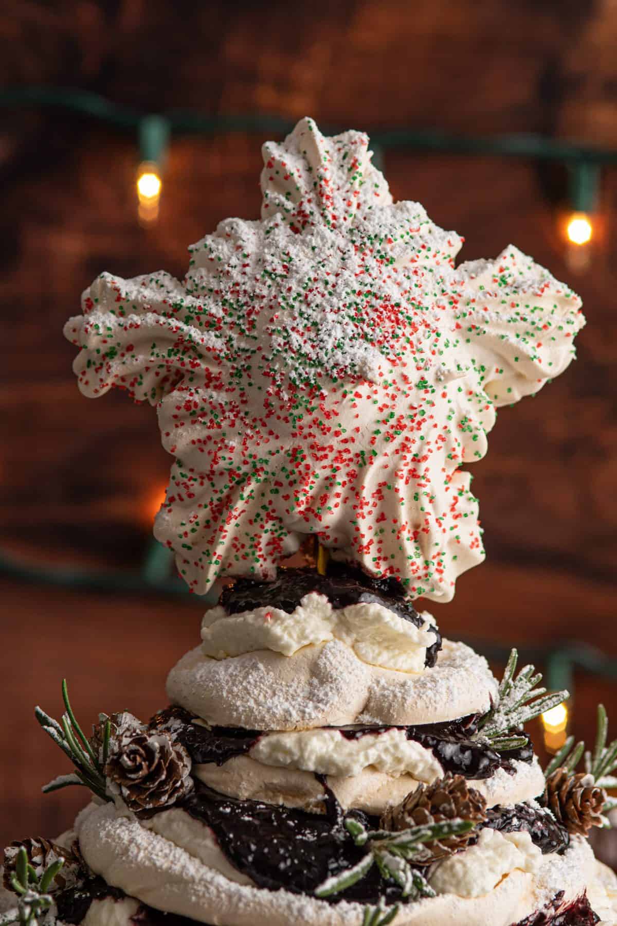 meringue star with sprinkles on top of the cherry pavlova tree