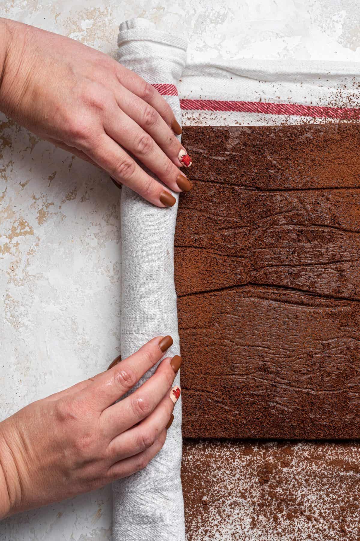 rolling the Yule log cake in a kitchen towel 