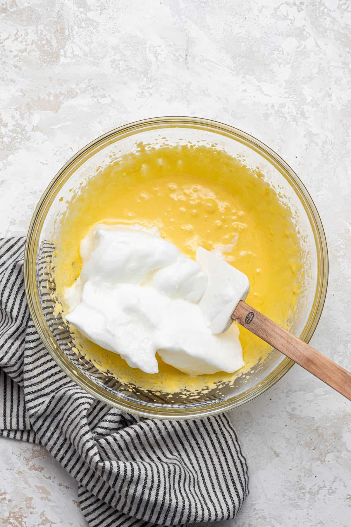 mixing the egg yolks with the whipped egg whites