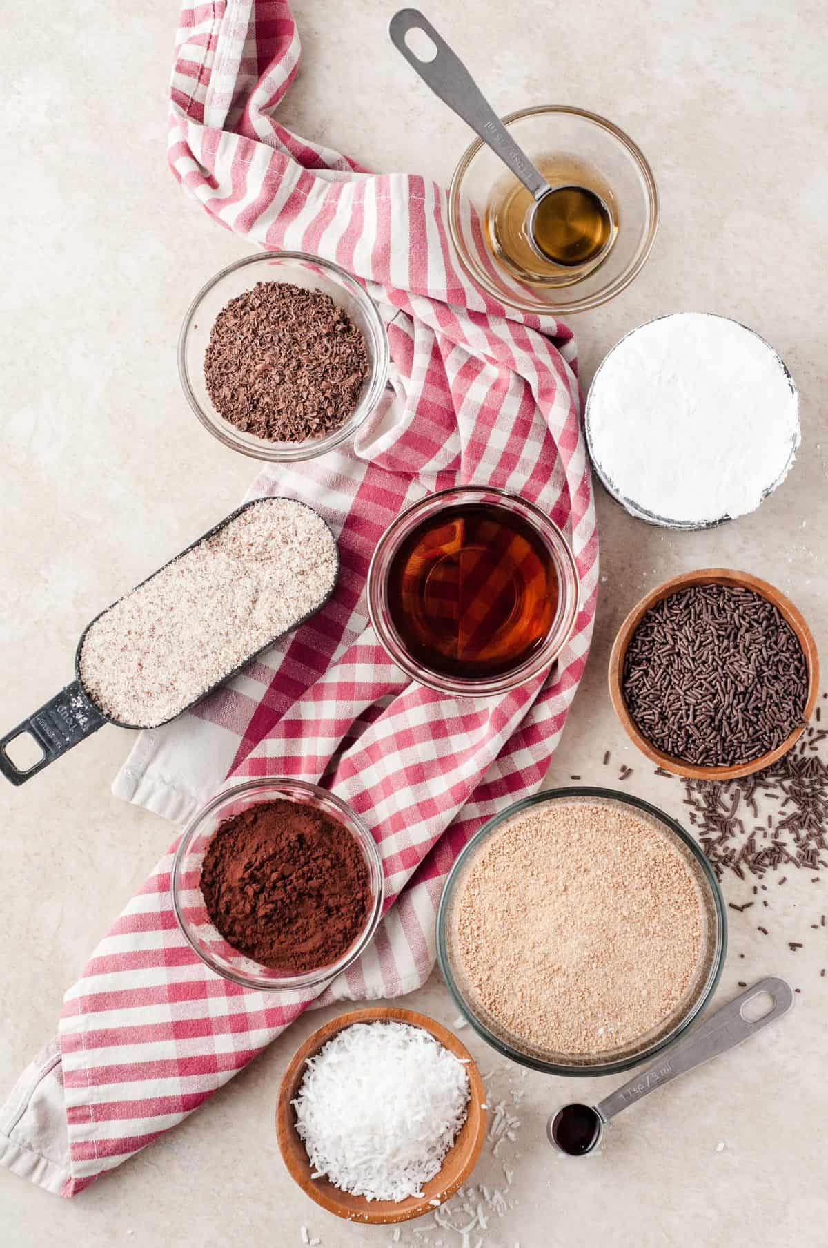 ingredients to make chocolate rum balls with red and white dishtowel in background