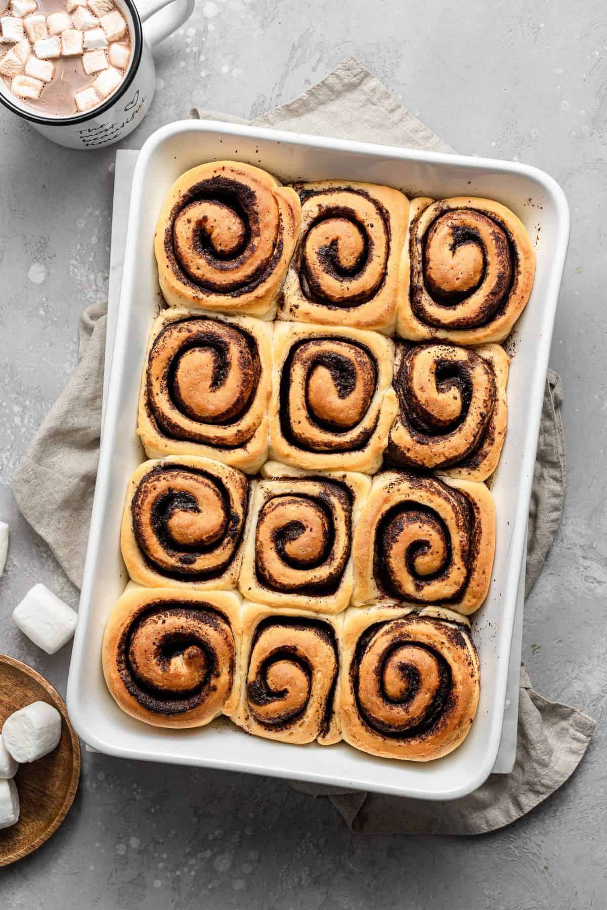 baked, unfrosted hot cocoa rolls in white tray