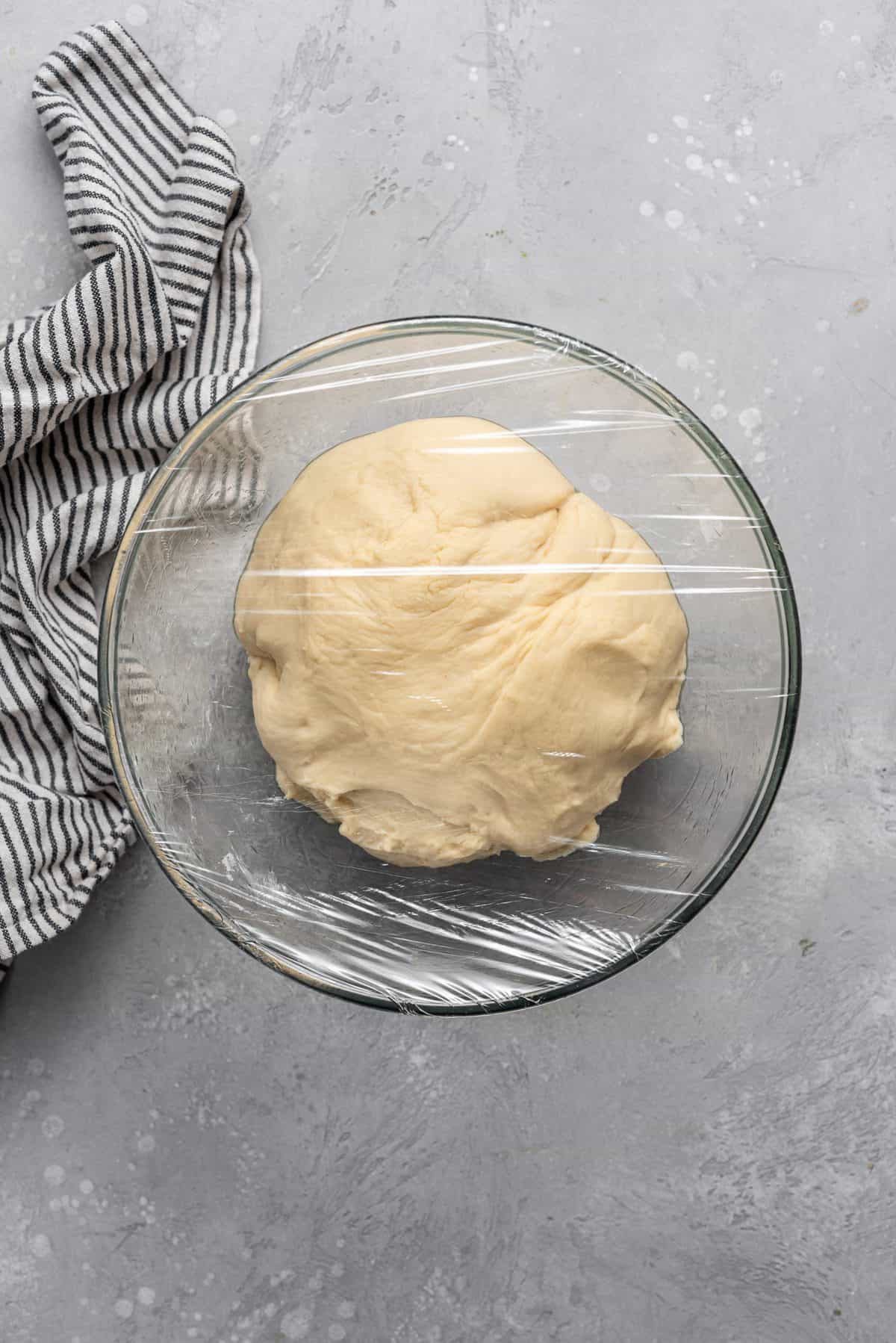 dough in a glass bowl waiting to rise