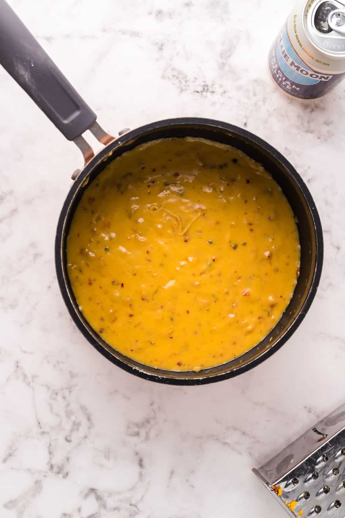 allowing the melted beer cheese to cool in a pan