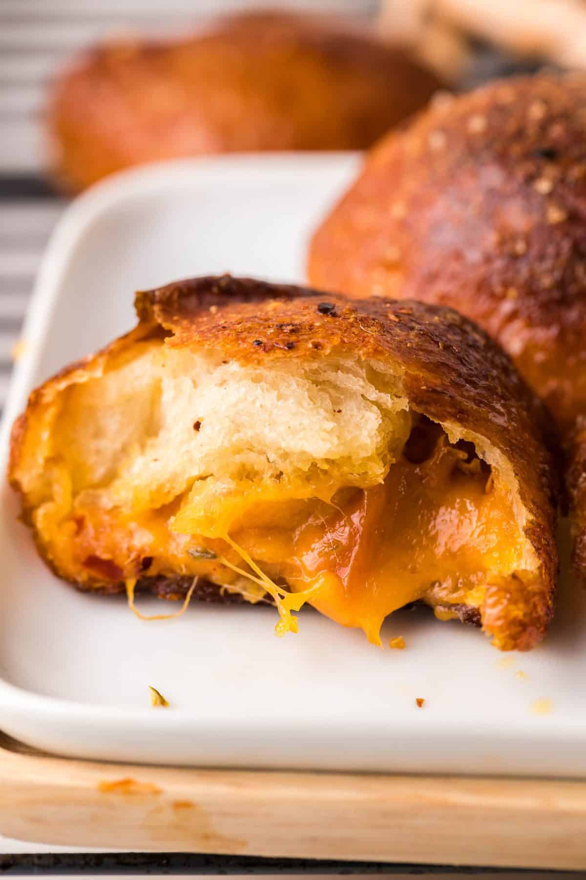 up close photo of a beer cheese filled pretzel ball broken in half to see the melty cheese
