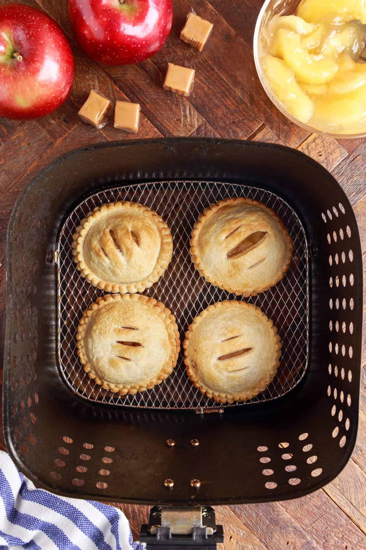 placing the pies in the air fryer to cook