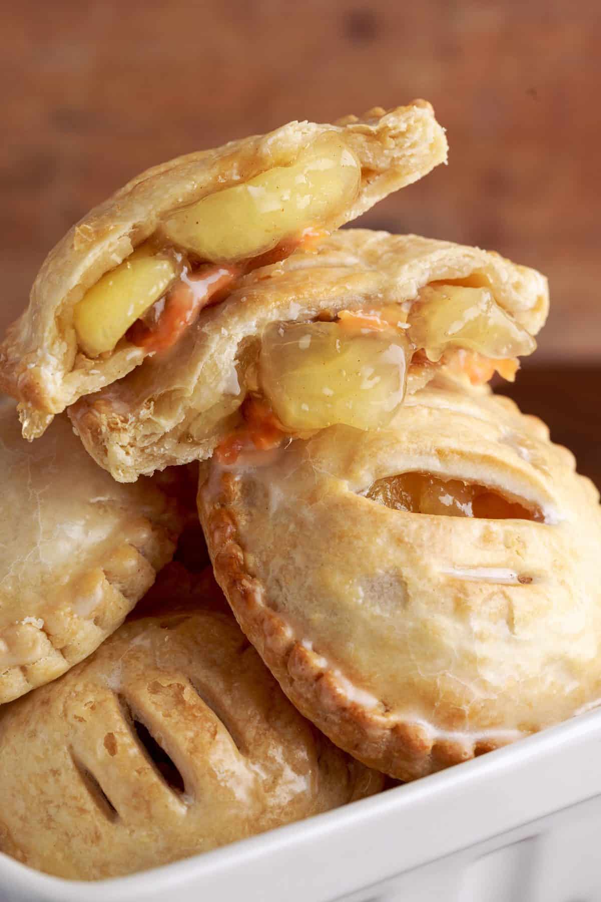 stacked caramel apple hand pies with top pie cut in half exposing the apple filling