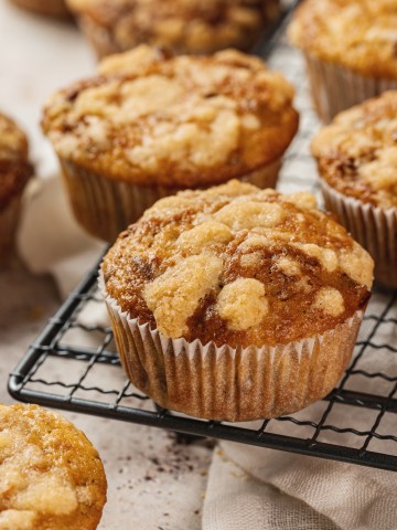 banana muffins with streusel topping sitting on a cooling rack