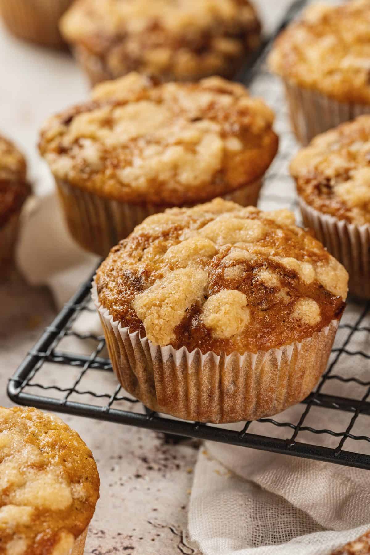 banana muffins with streusel topping sitting on a cooling rack