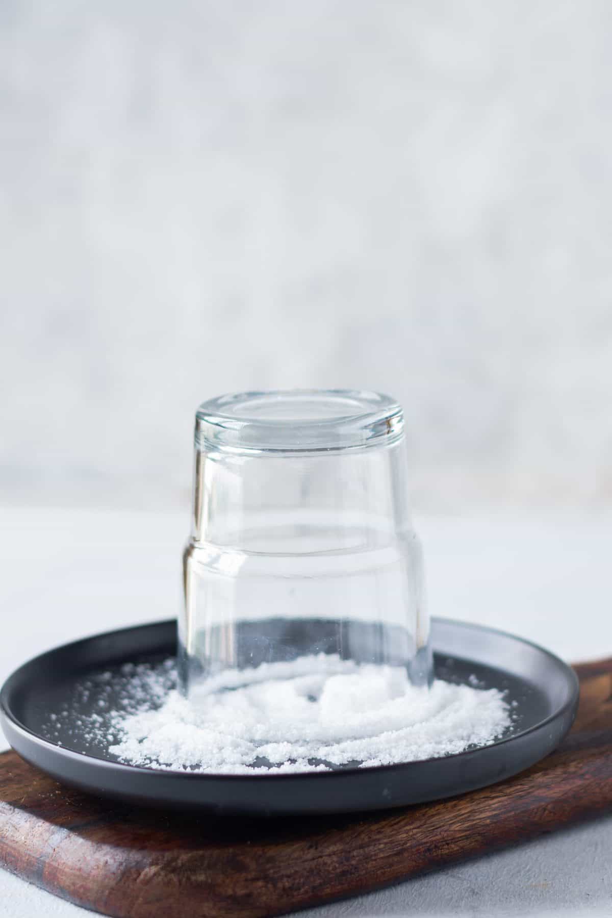 dipping the rim of glass into a plate of salt for margaritas.