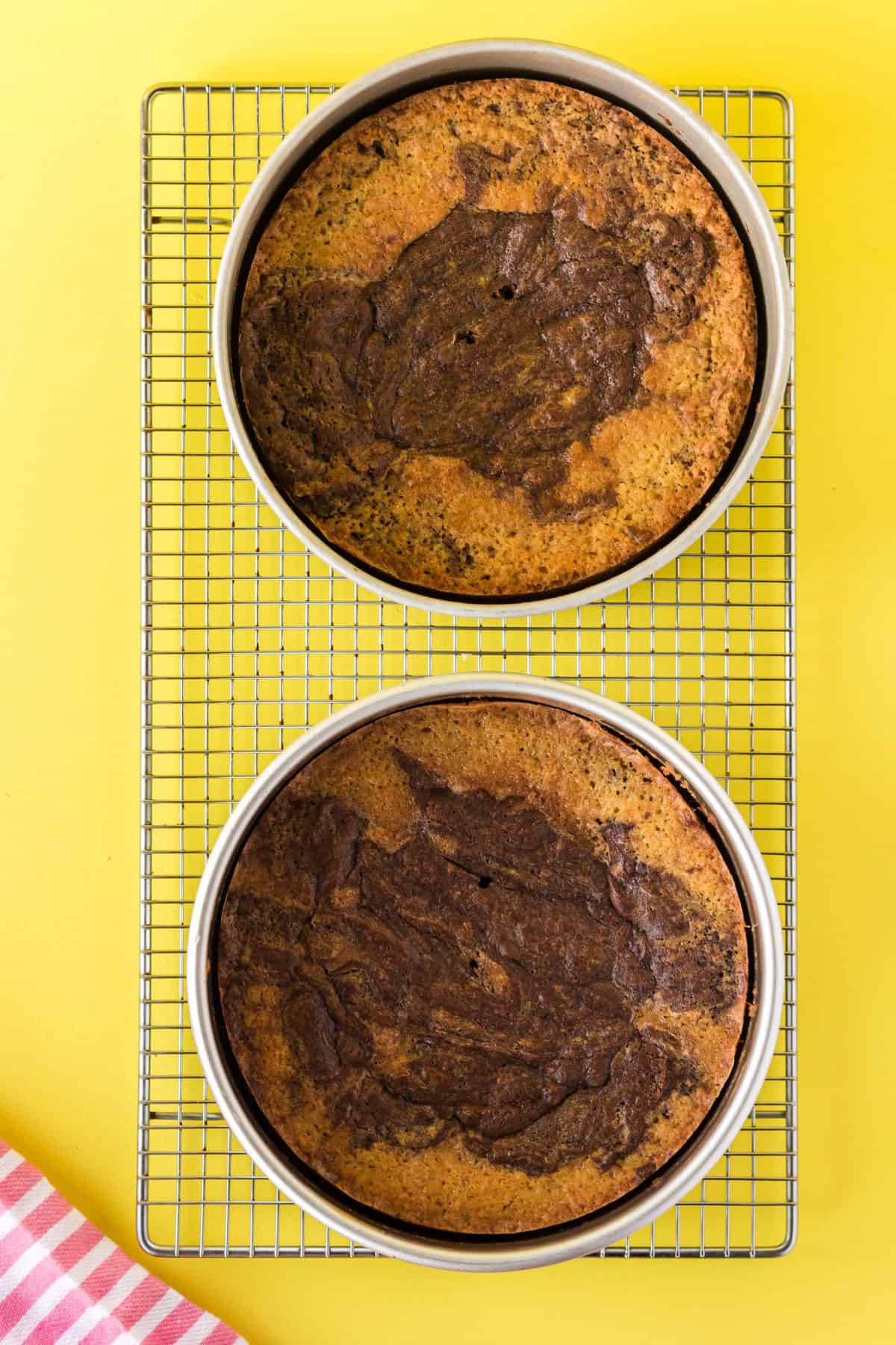 cake pans with marble cake on a cooling rack