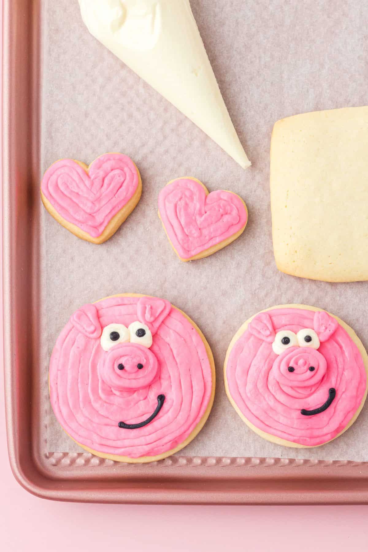 adding the eyes and mouth to the pig sugar cookies