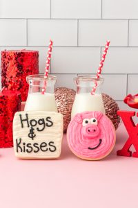 pig sugar cookies with jars of milk in the background