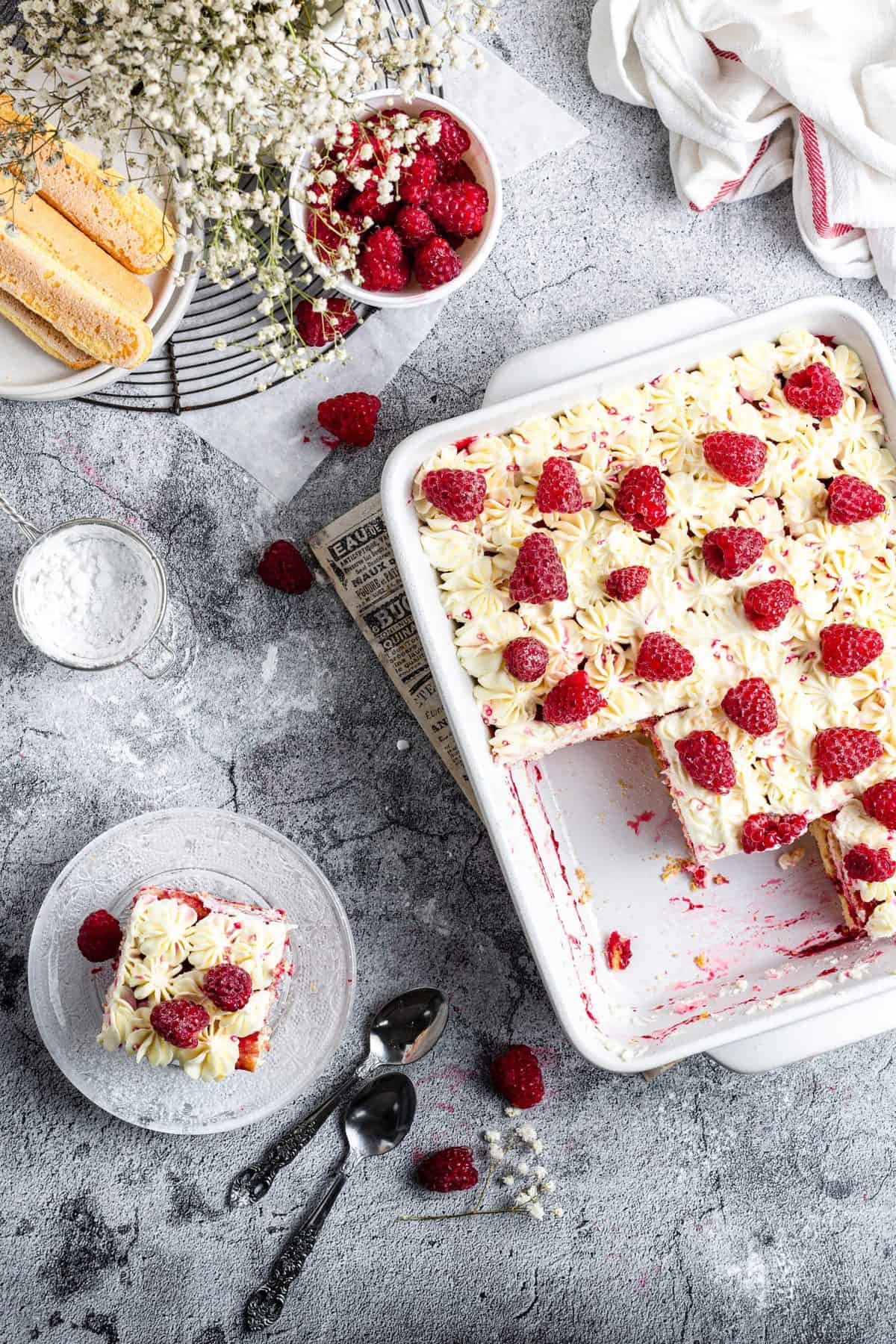 overhead shot of baking dish with raspberry amaretto tiramisu with slices plated around the baking dish