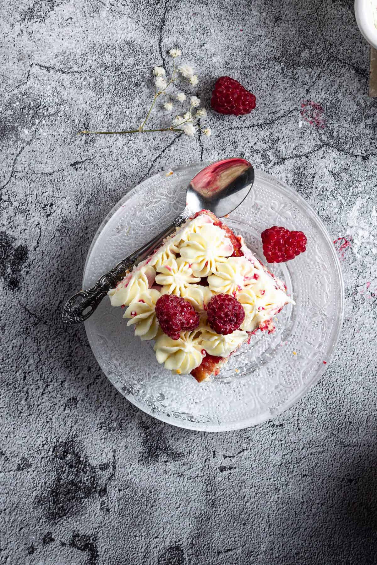 overhead shot of a slice of raspberry amaretto tiramisu on white plate