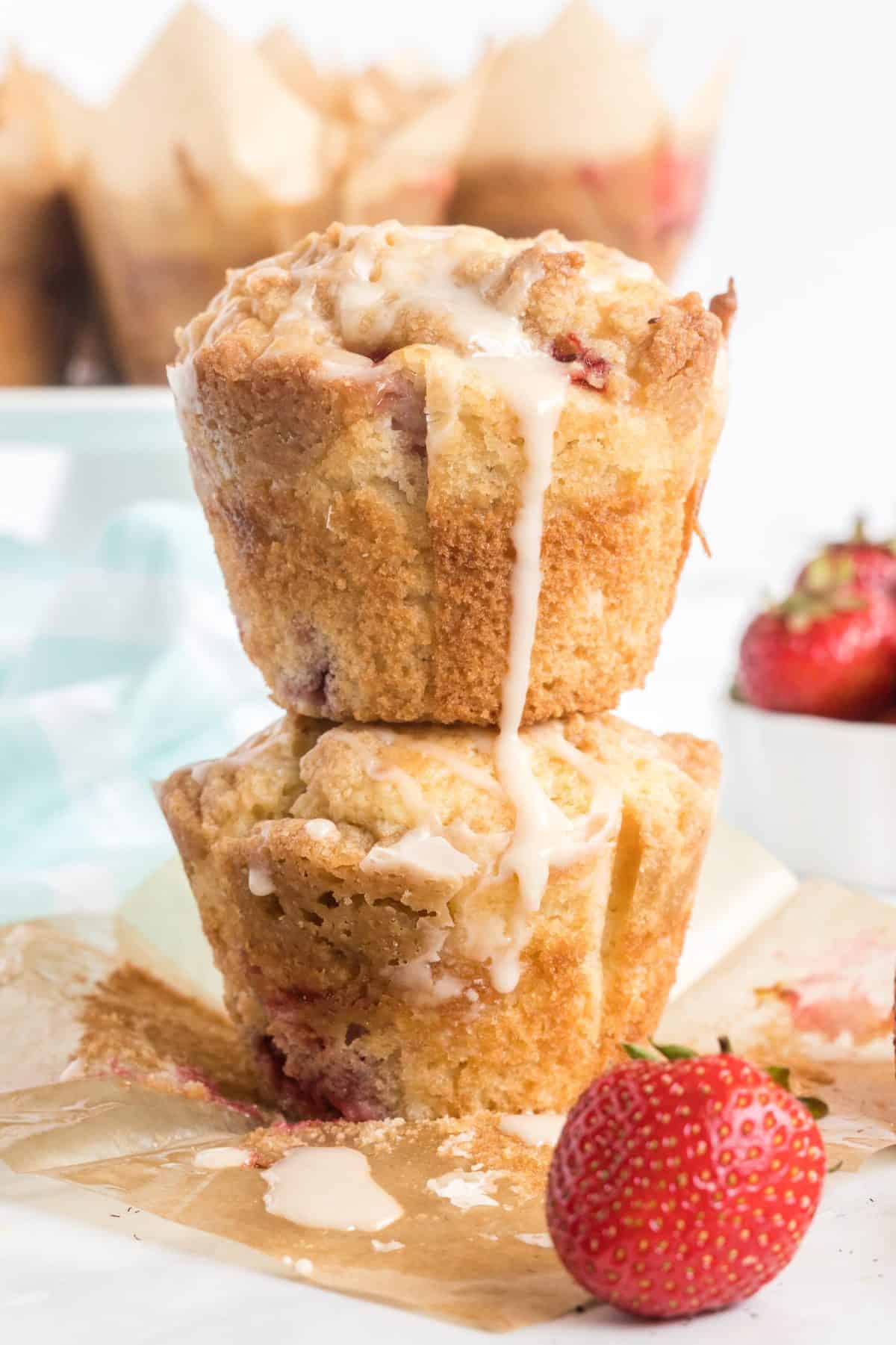 two muffins stacked with fresh strawberries around them