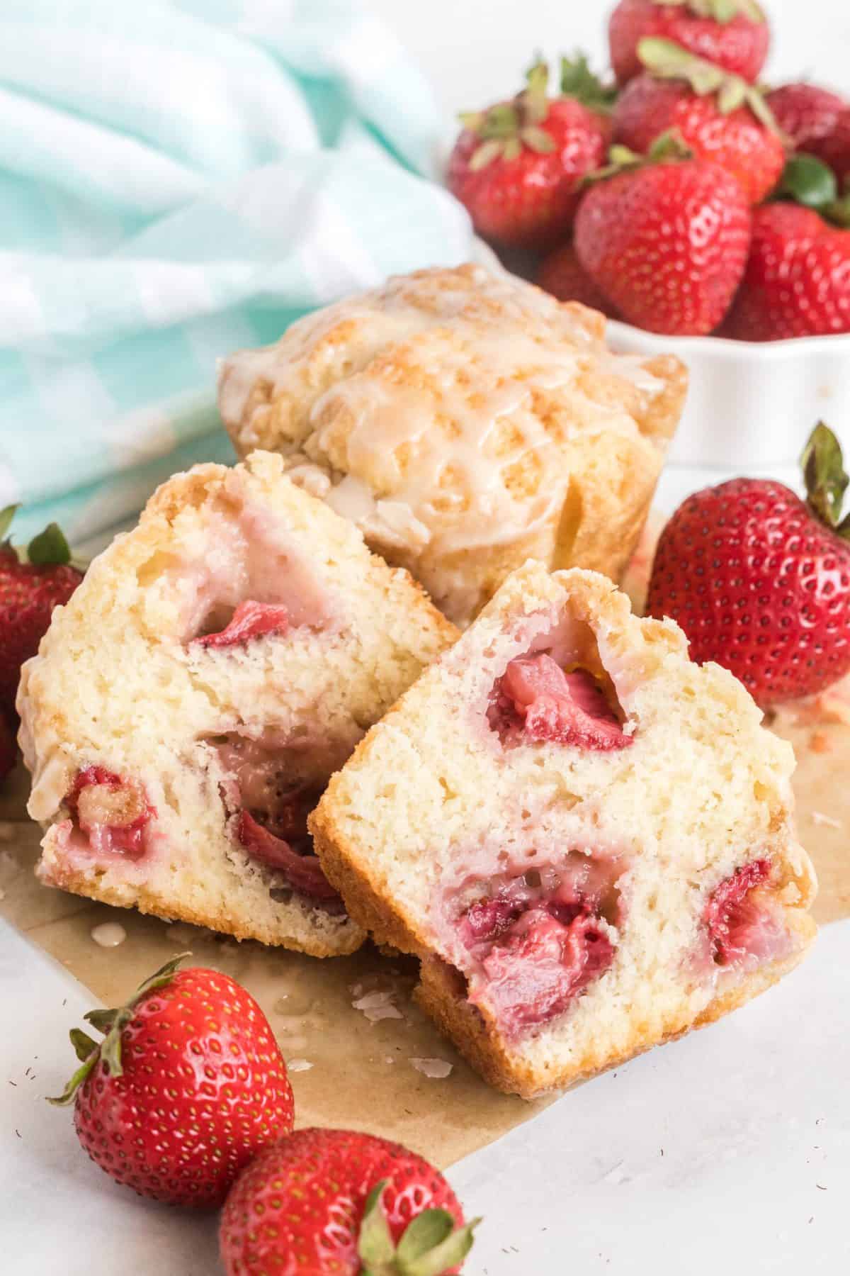 A muffin cut in half showing the fresh strawberries baked into the batter. 