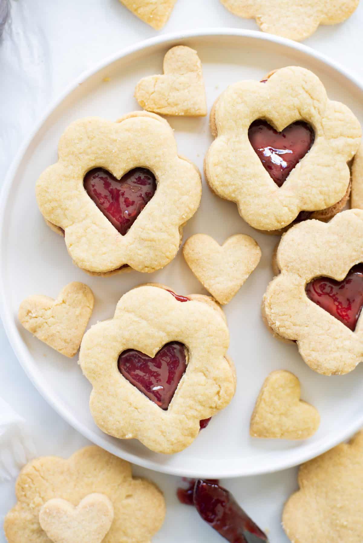 heart valentines day cookie sandwiches on a white plate on marble background. 
