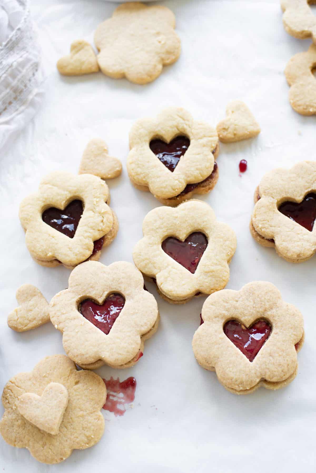 heart cookie sandwiches laid out in a cluster on white background.