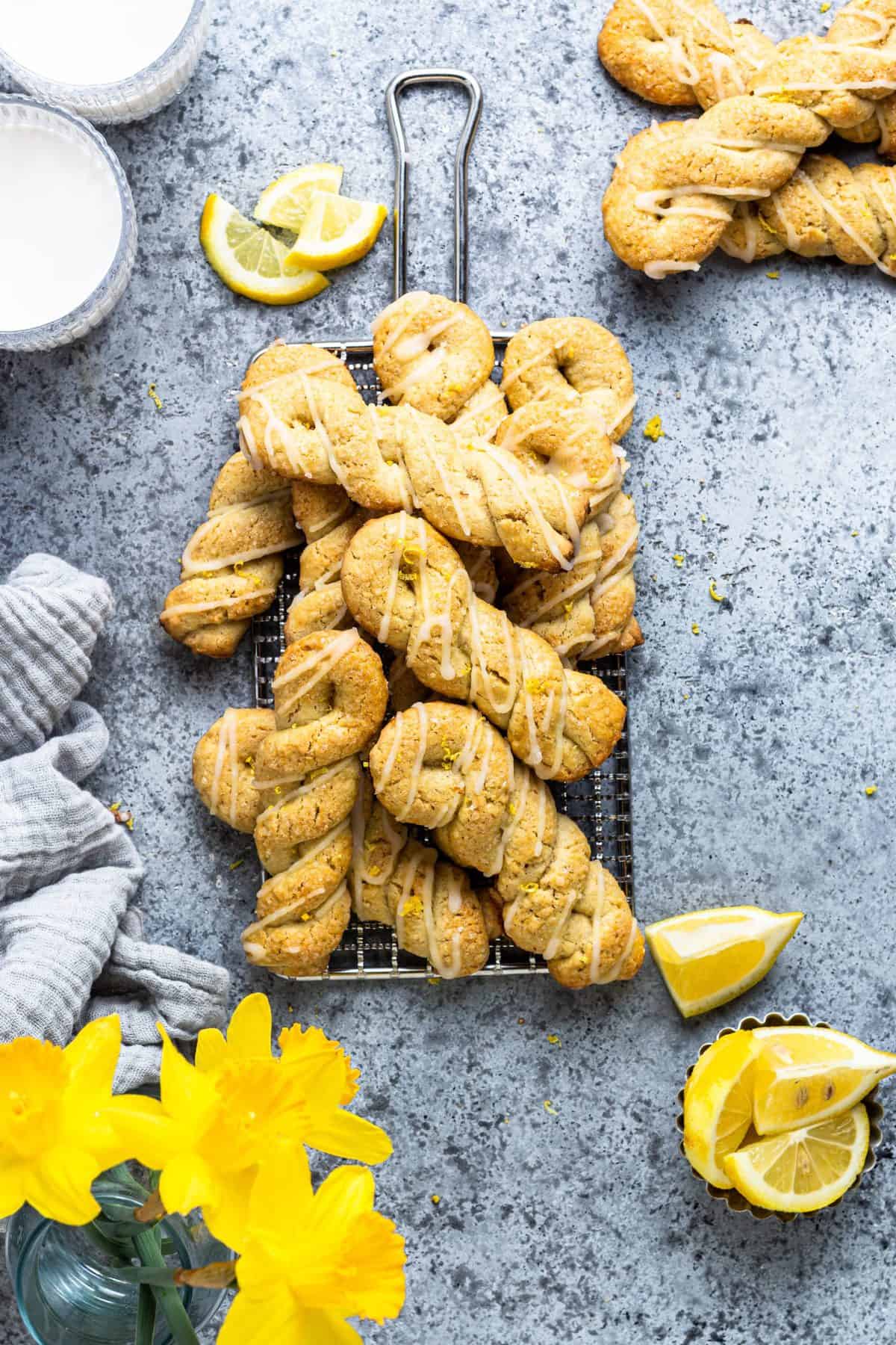 Vintage cooling rack with lemon twist cookies stacked on it on a metal background