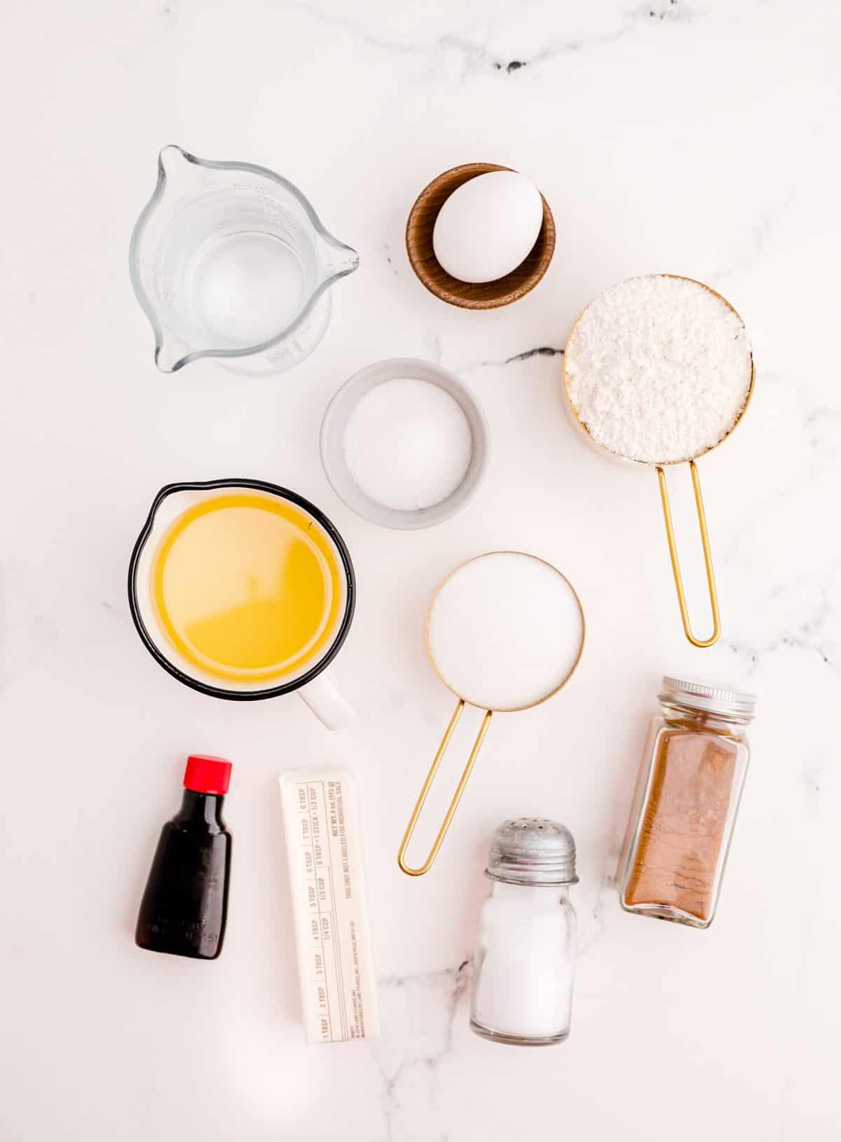 Ingredients to make homemade churros laid out on a white background.