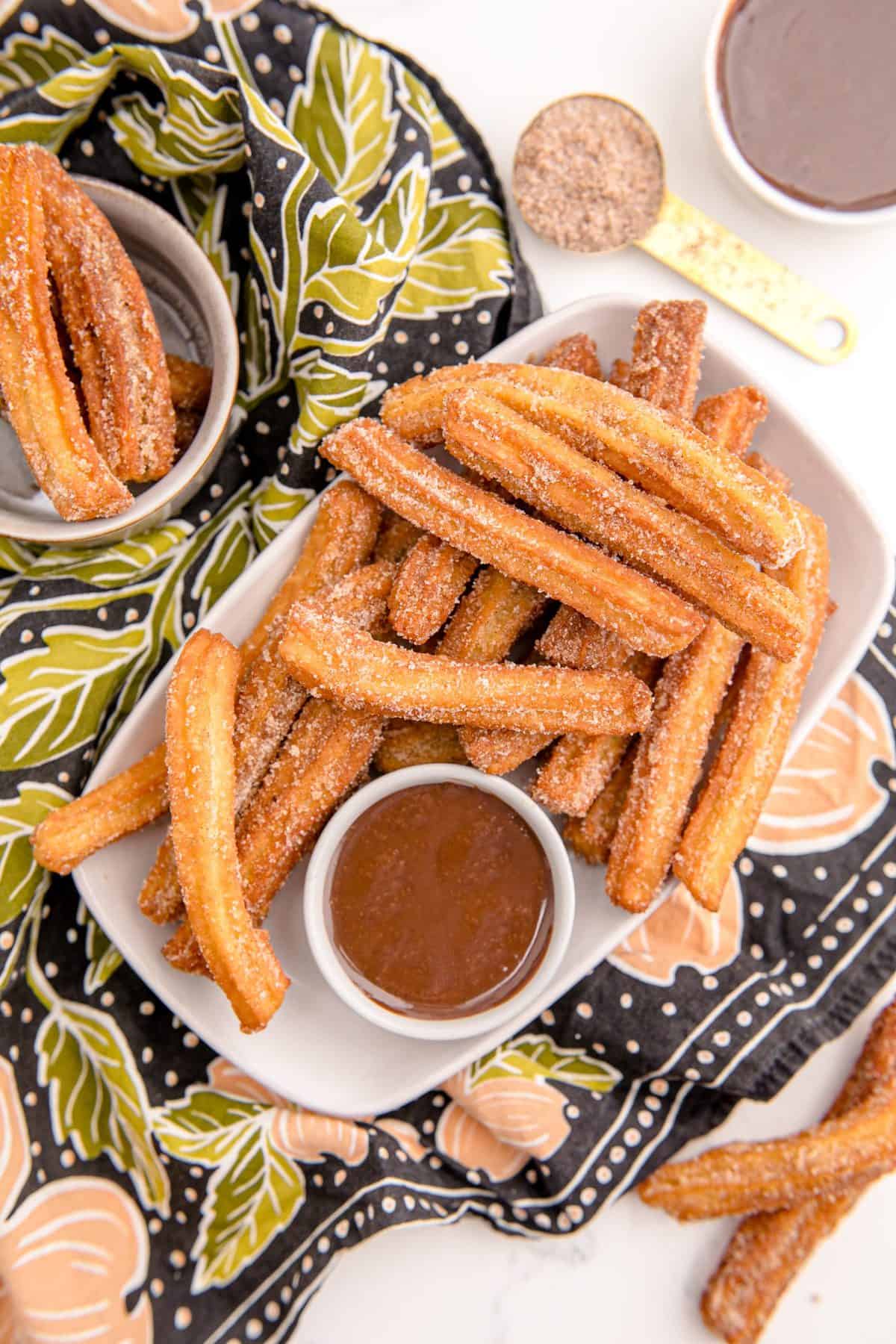 Overhead shot of a plate of churros and chocolate sauce.