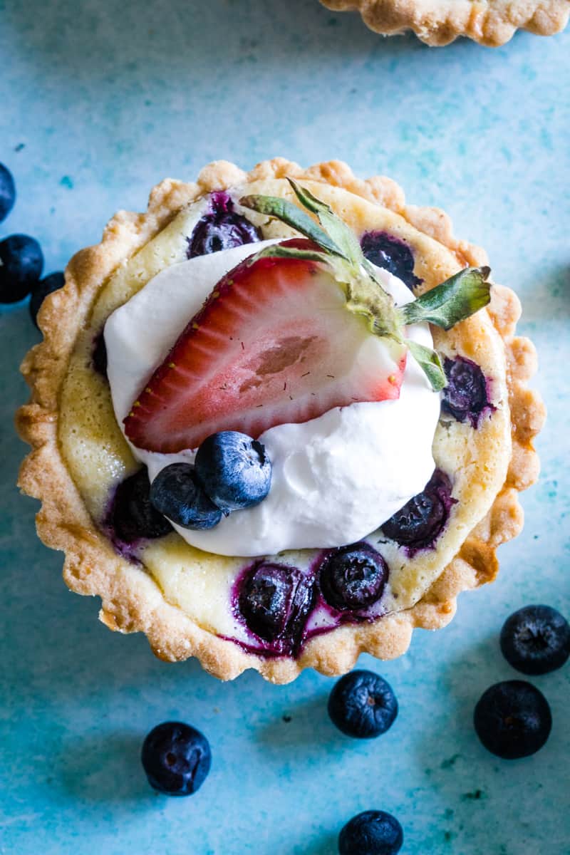 Overhead shot of Berry Tart topped with whipped cream and strawberry. 
