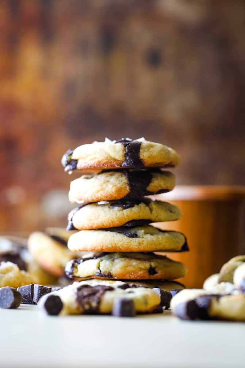 Stacked cookies with a wooden jar of sea salt in background. 