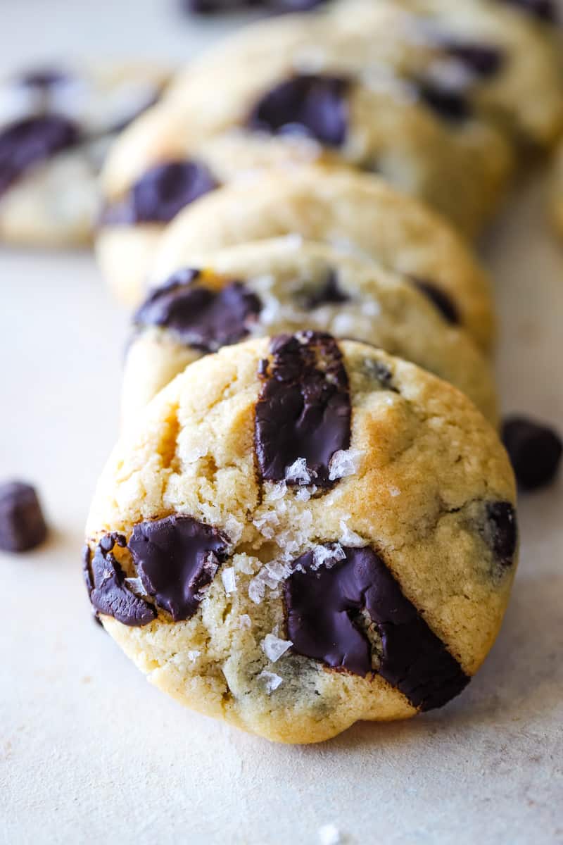 Closeup of an almond flour chocolate chip cookie with sea salt flakes. 