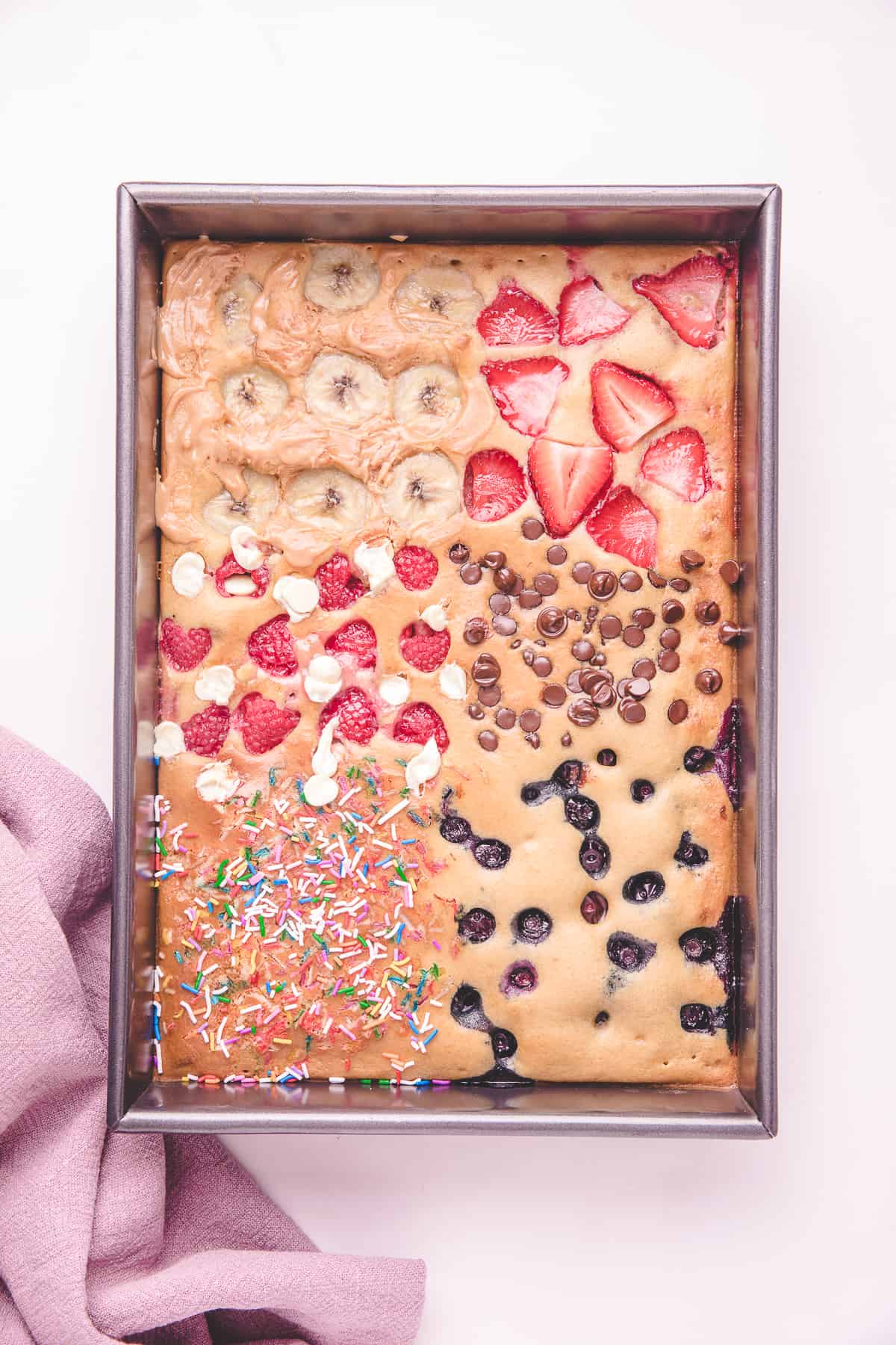 Overhead shot of sheet pan pancakes with berries and chocolate chips. 