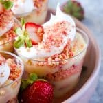 Strawberry pudding cups on pink plate and metal background.